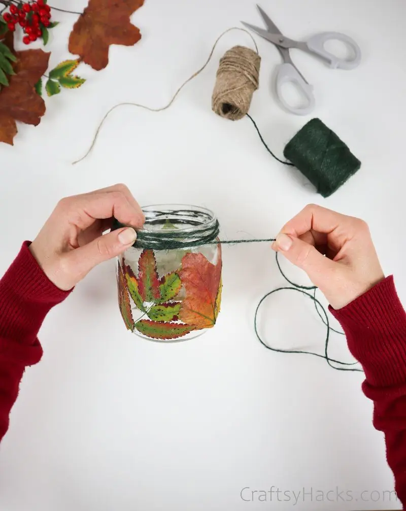 wrapping green twine around jar