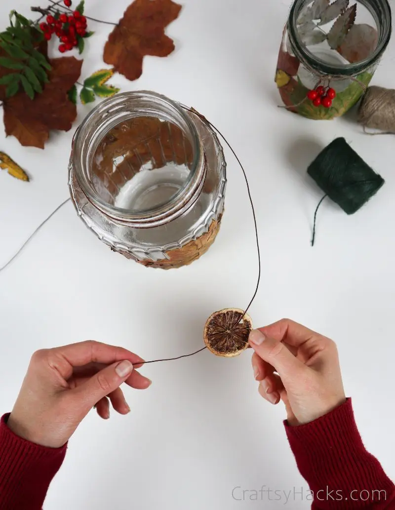 stringing dried fruit slice onto twine