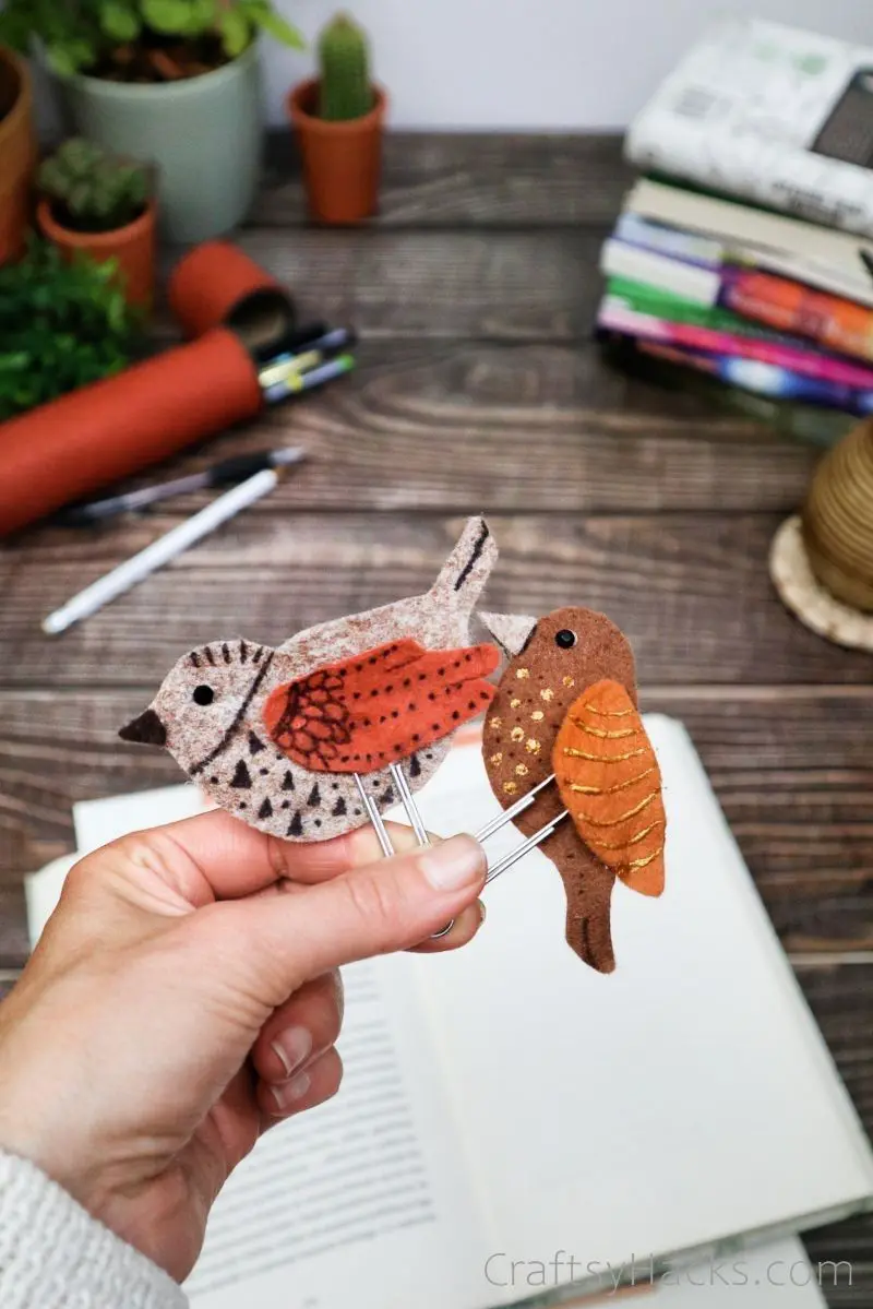 holding two completed bird bookmarks