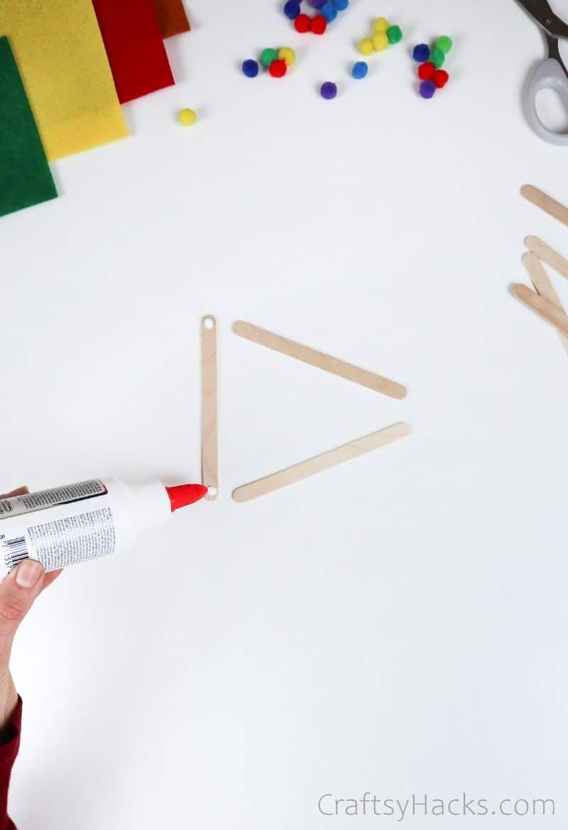 putting glue on popsicle sticks