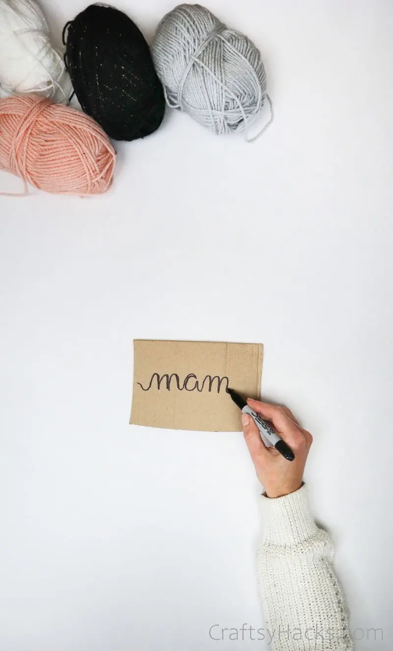 four balls of yarn with cardboard piece