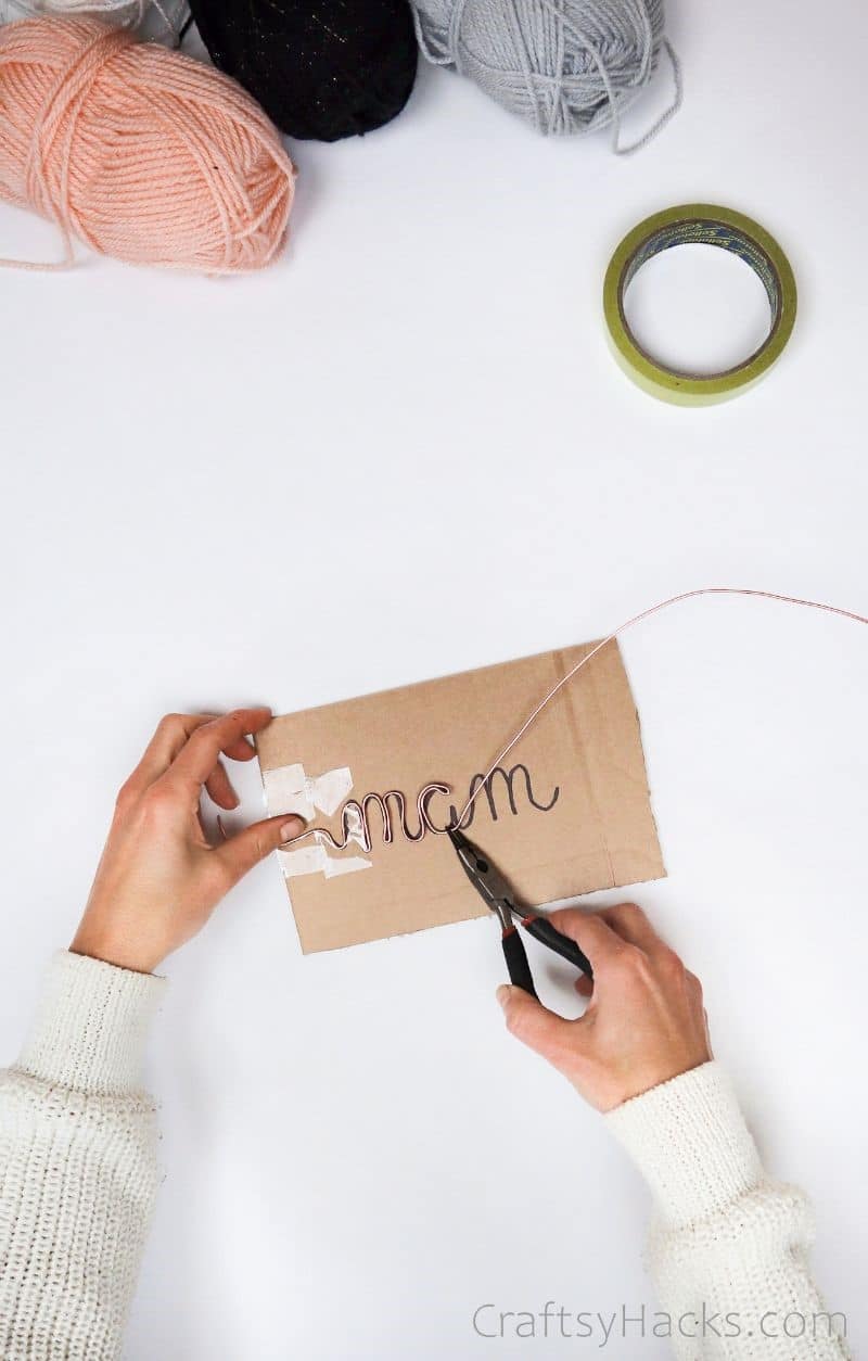 tracing wire over writing on cardboard