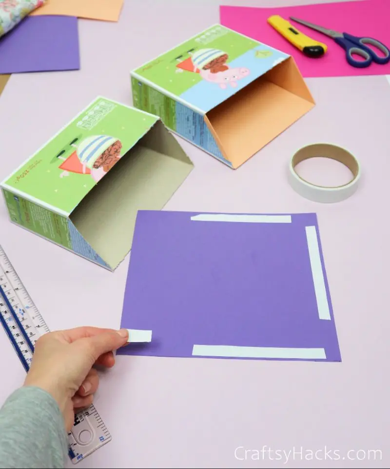 adding adhesive strip to purple paper
