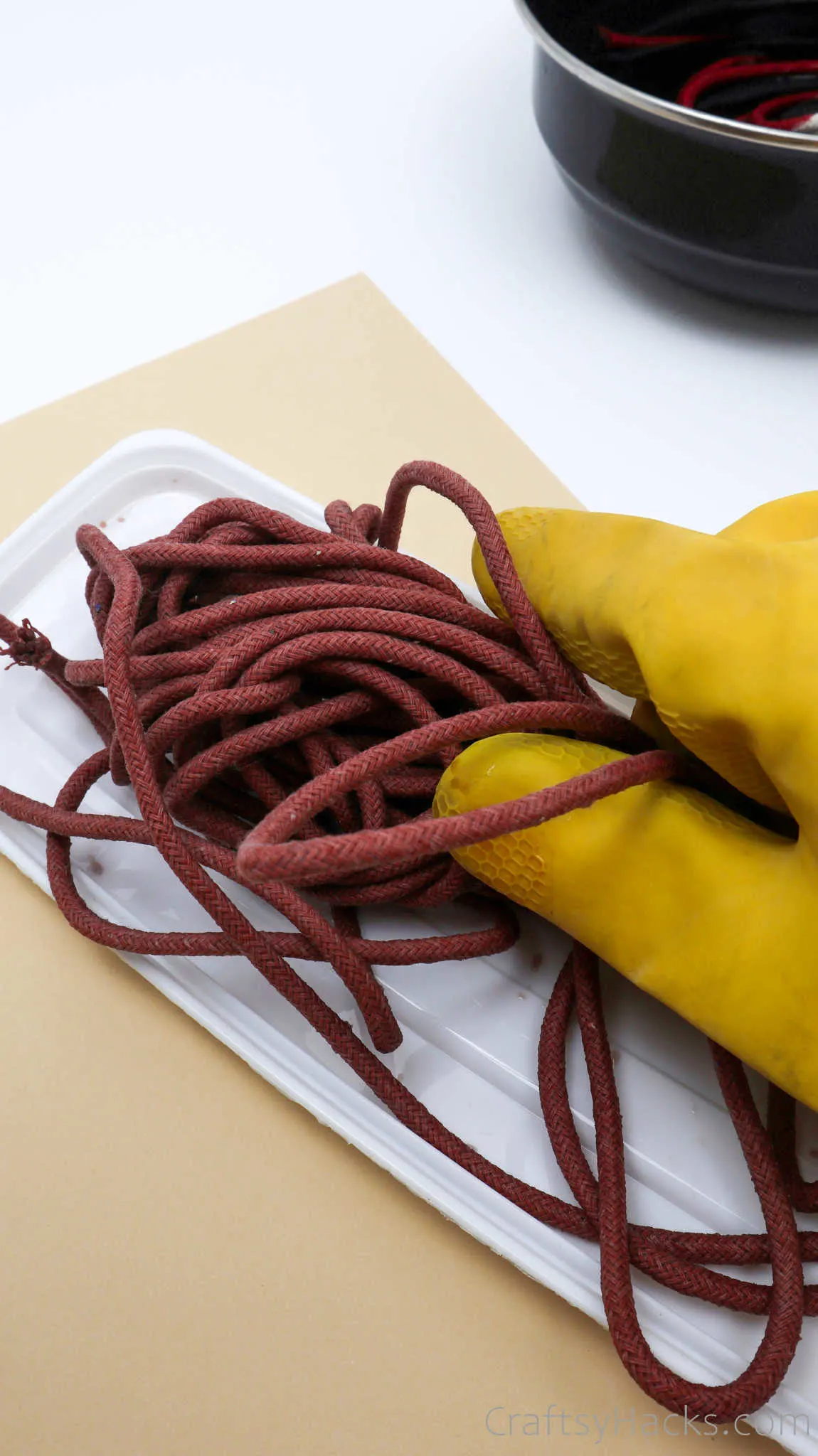 holding red dyed rope with glove