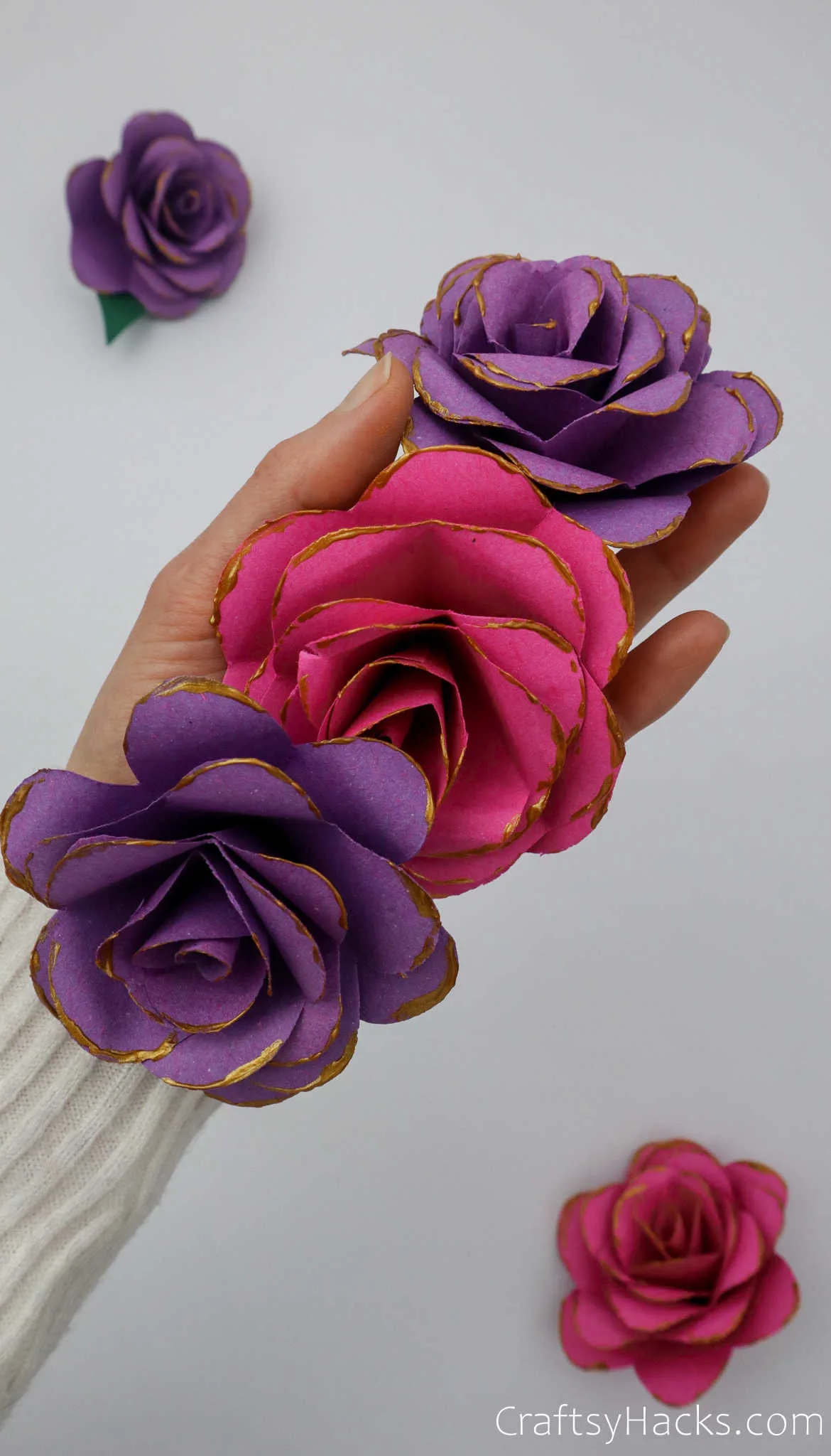 holding three paper flowers