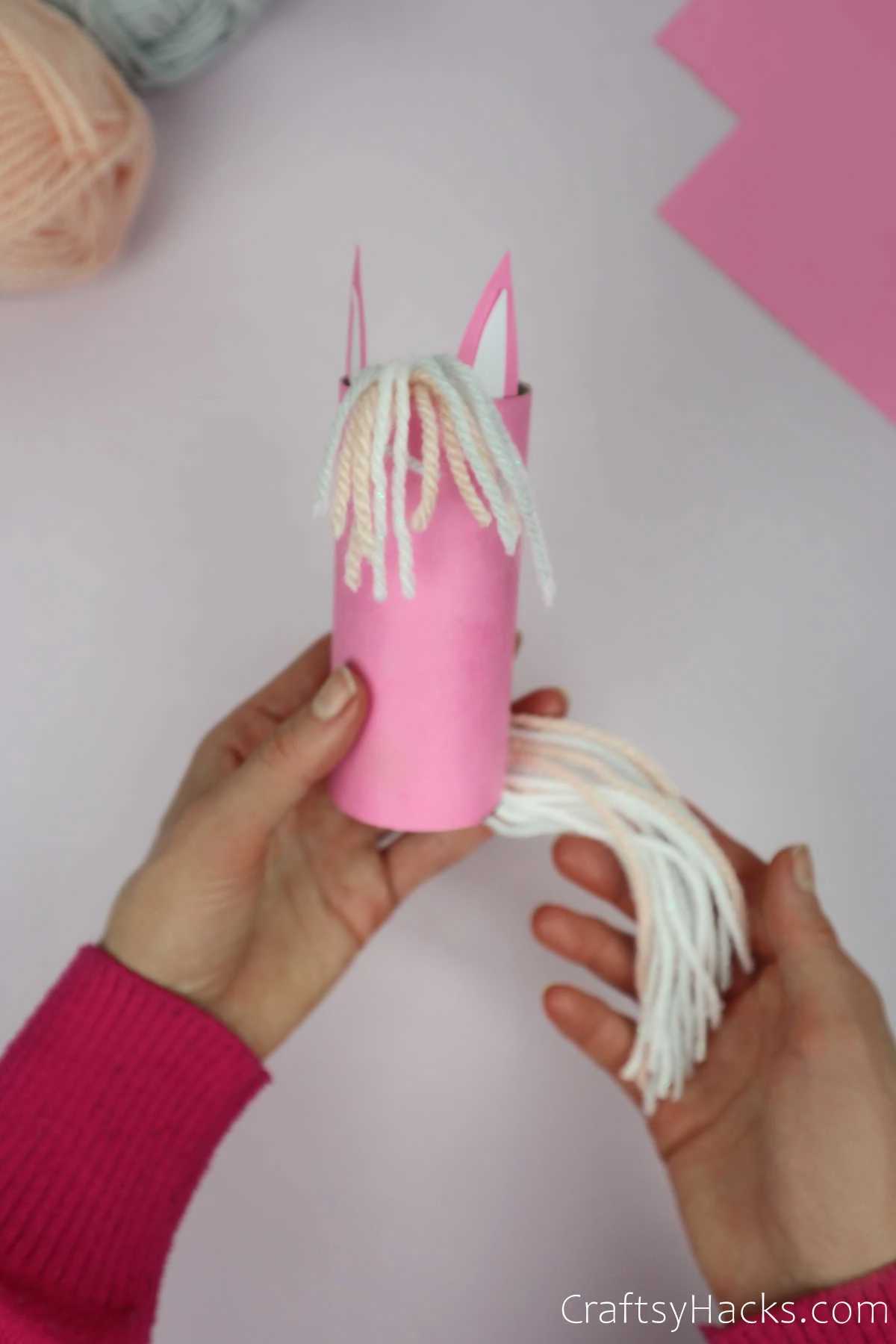 holding unicorn with yarn