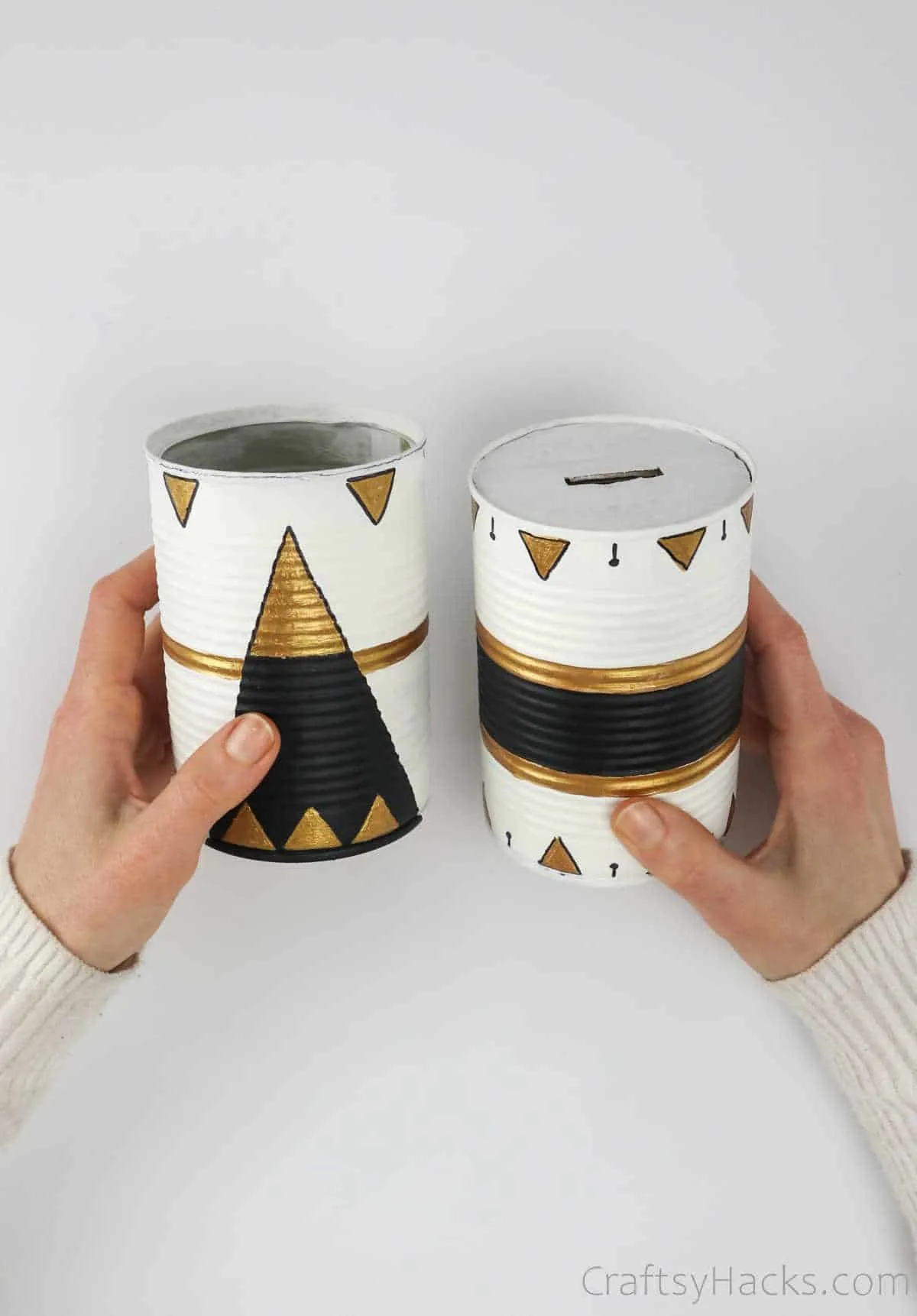 holding two tin cans painted