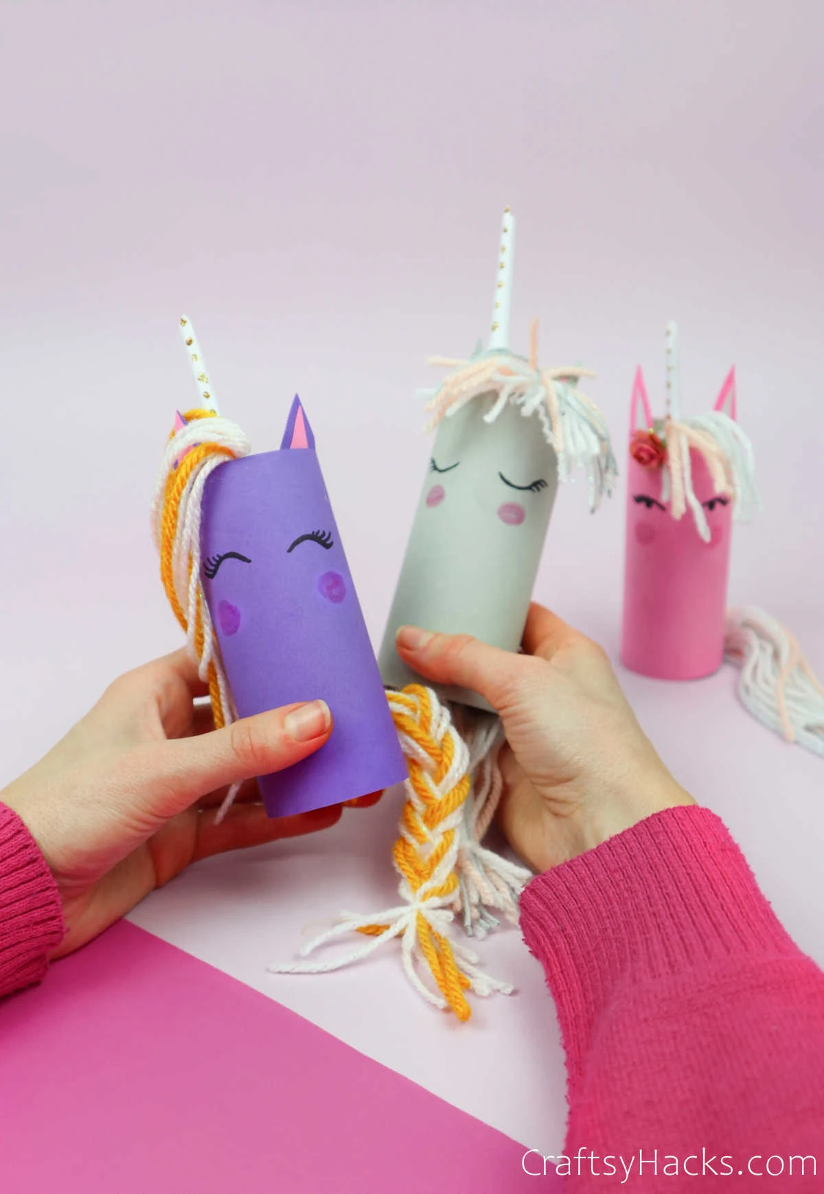 holding two paper roll unicorns