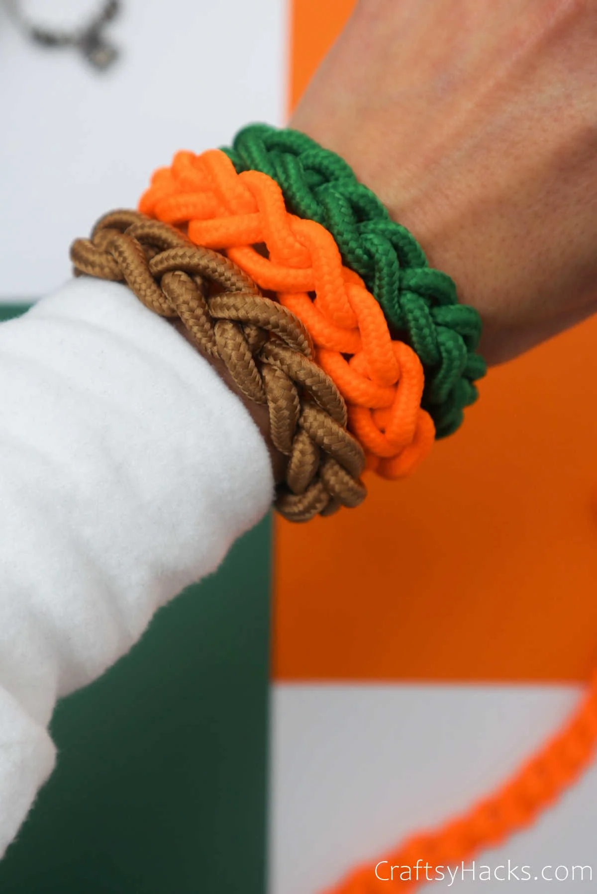 green, orange, and brown DIY bracelets on wrist