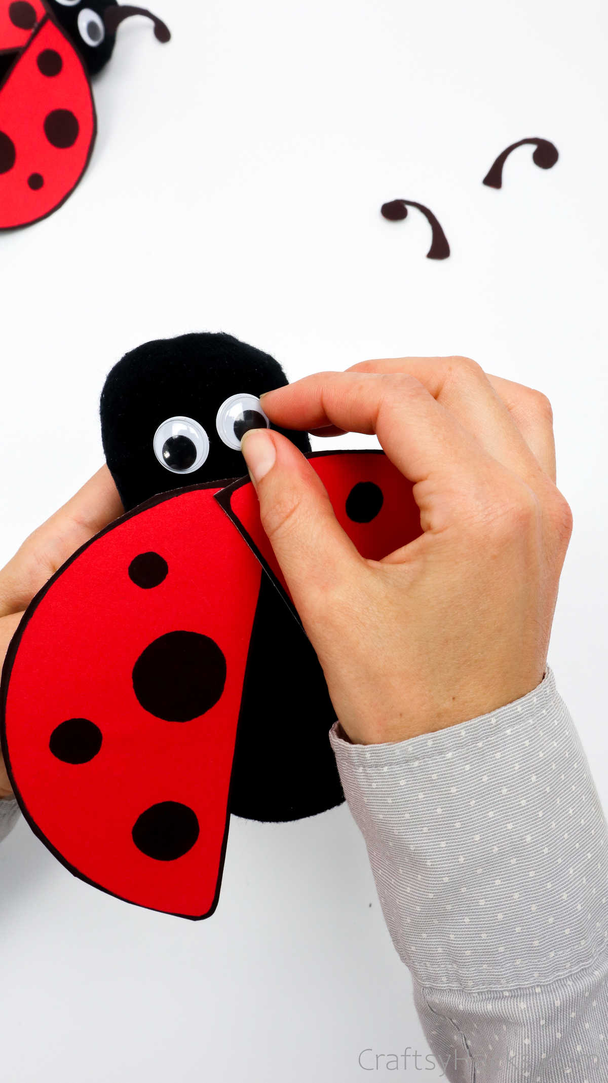 glueing eyes to ladybug