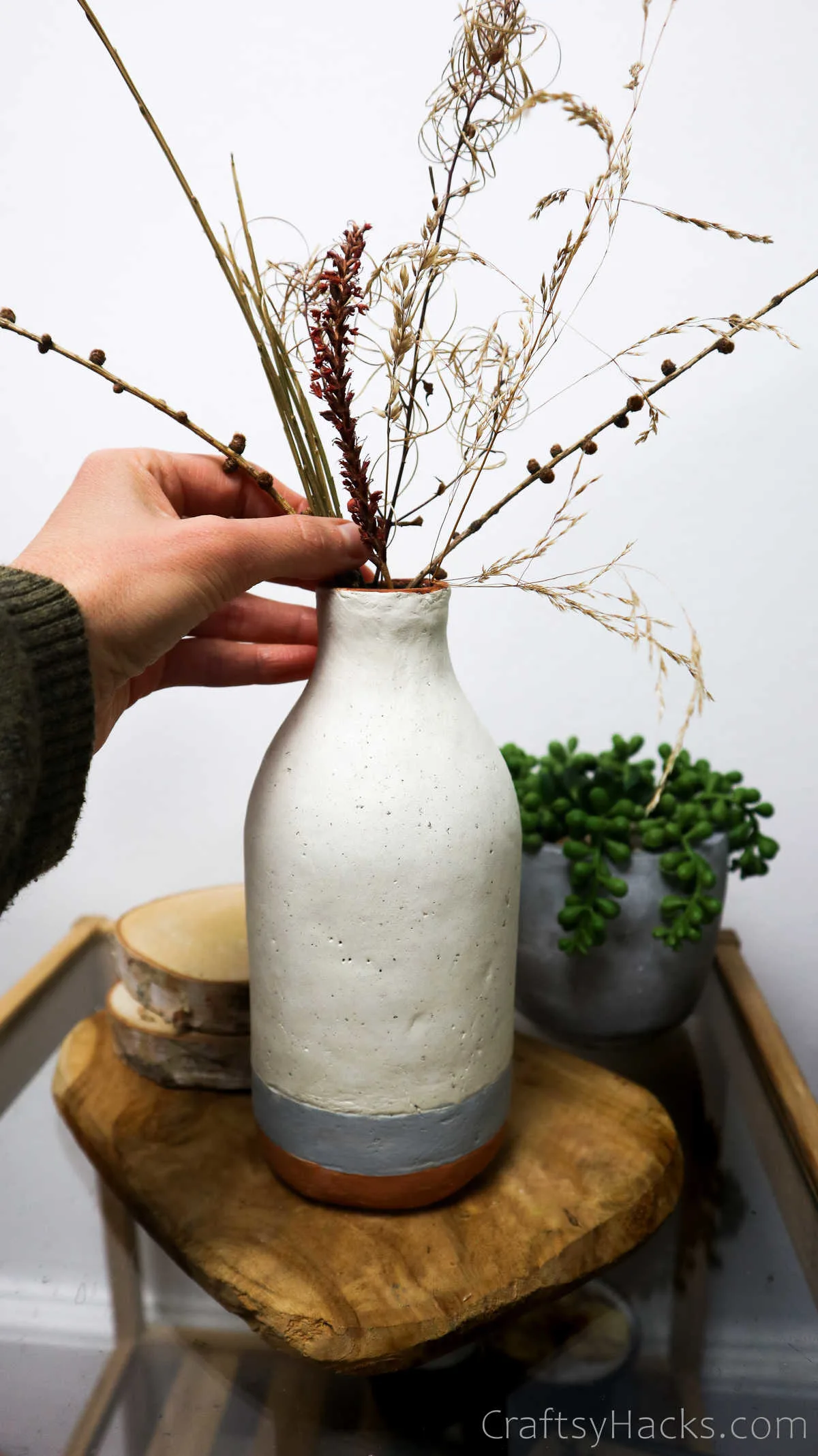 adding dried flowers to vase