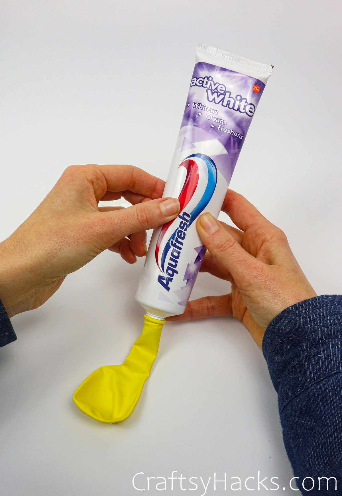 squeezing toothpaste into balloon