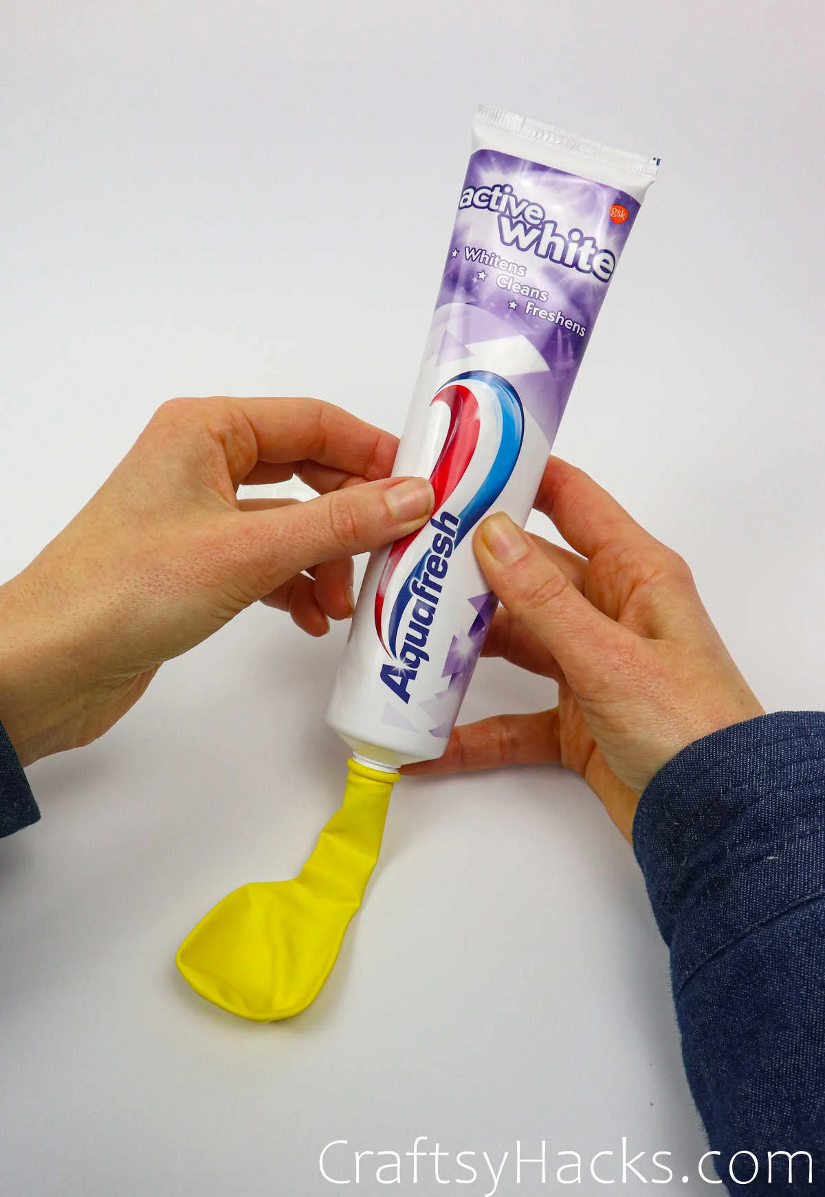squeezing toothpaste into balloon