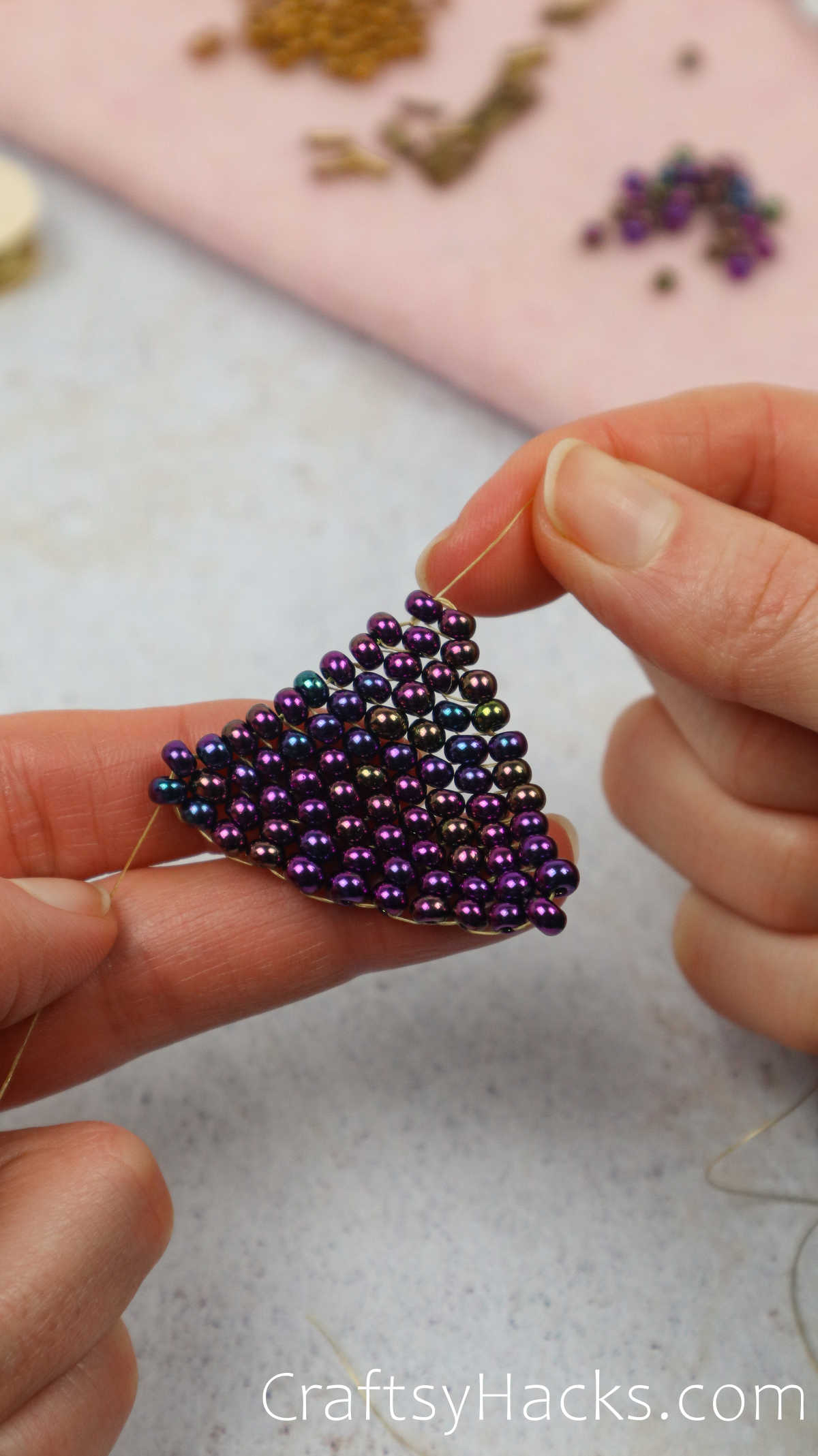 threading beads together to form a traingle shape
