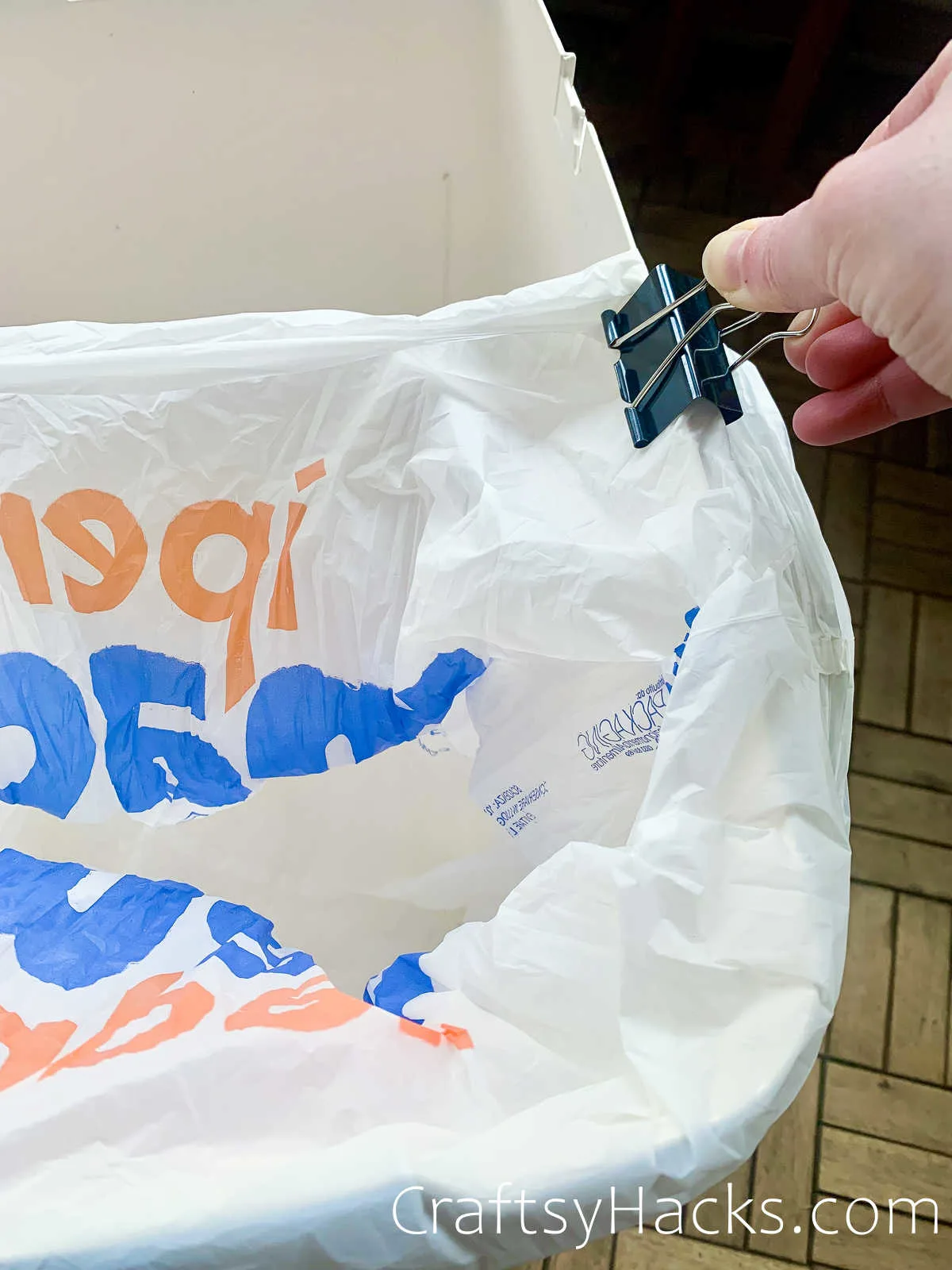 holding trash bags in bin with binder clip