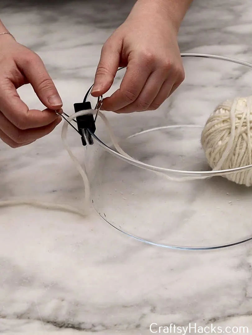 use a binder clip to hold ball of yarn in place