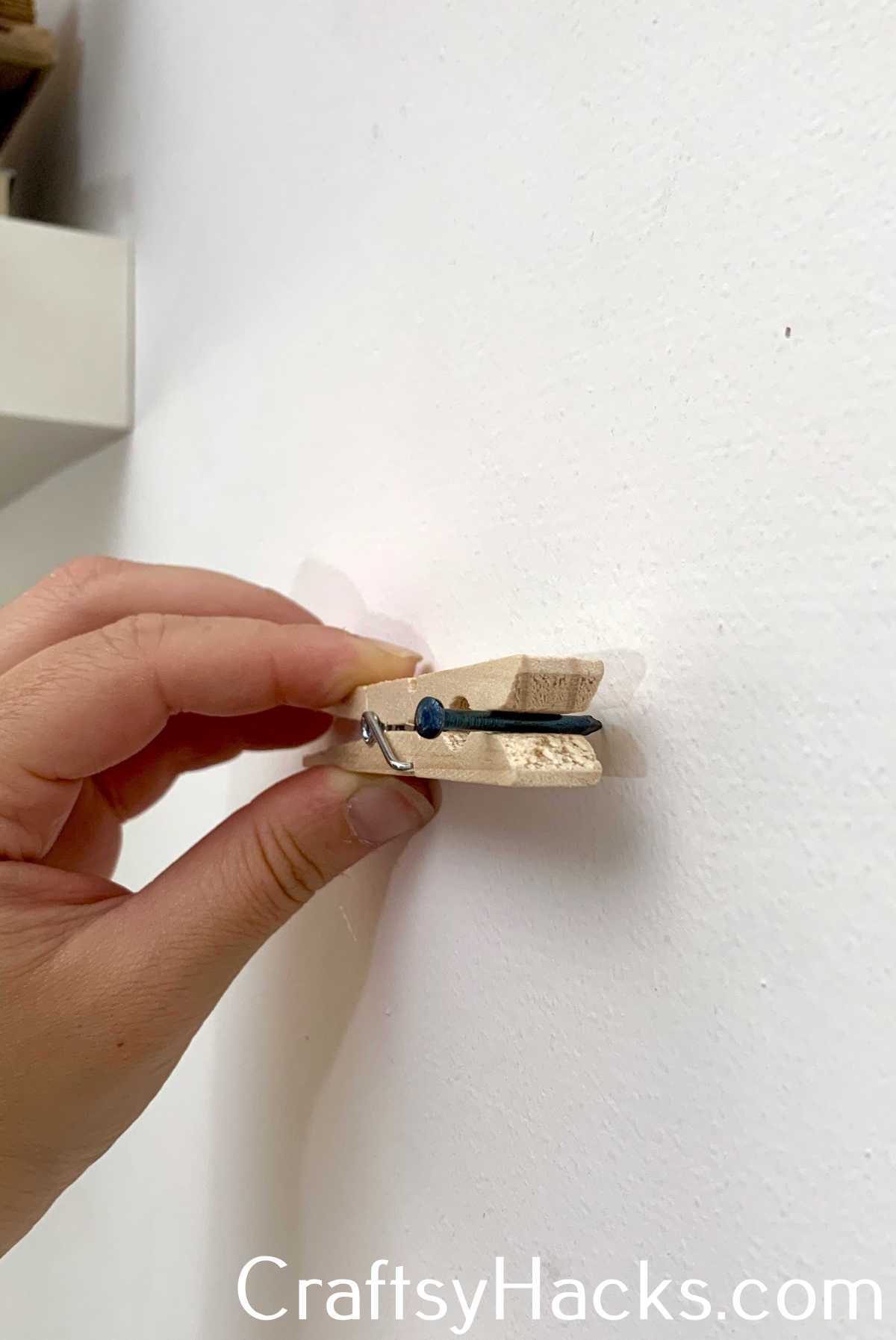 use clothes pegs to hold a nail in place