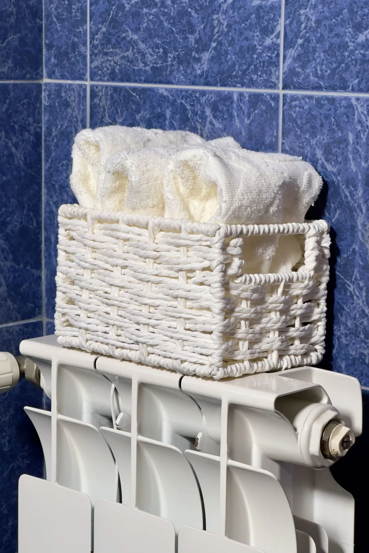 Place A Basket With Hand Towels On The Radiator